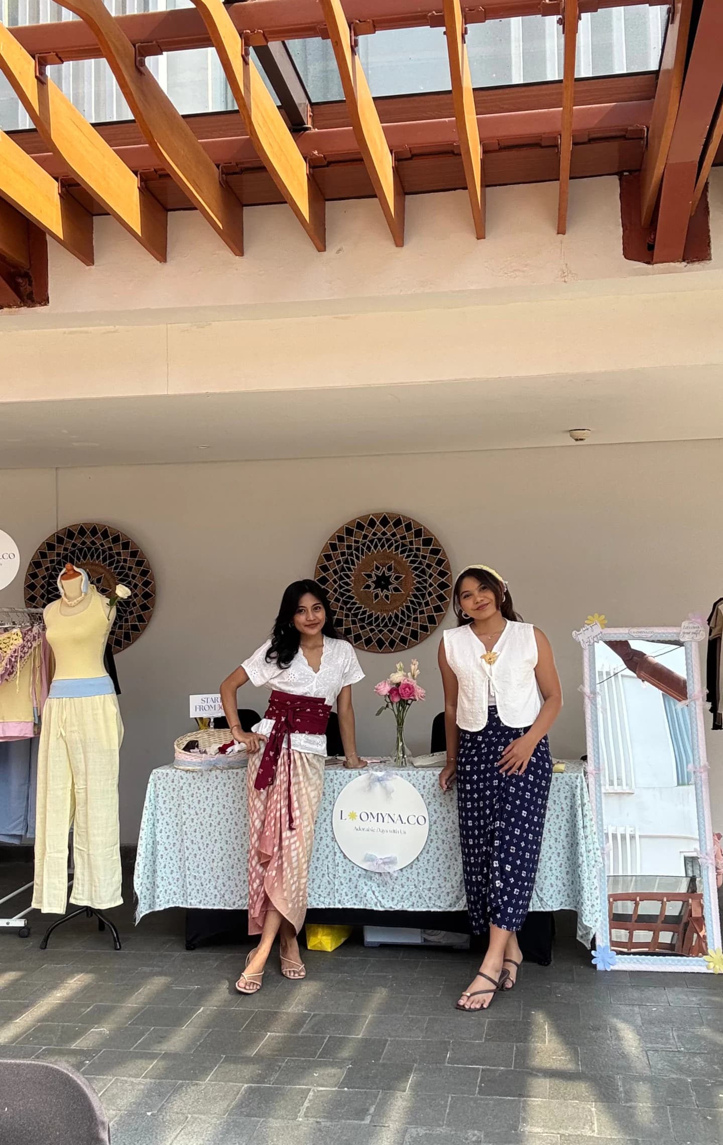 Two women by the sea wearing soft blue and butter yellow Loomyna tops